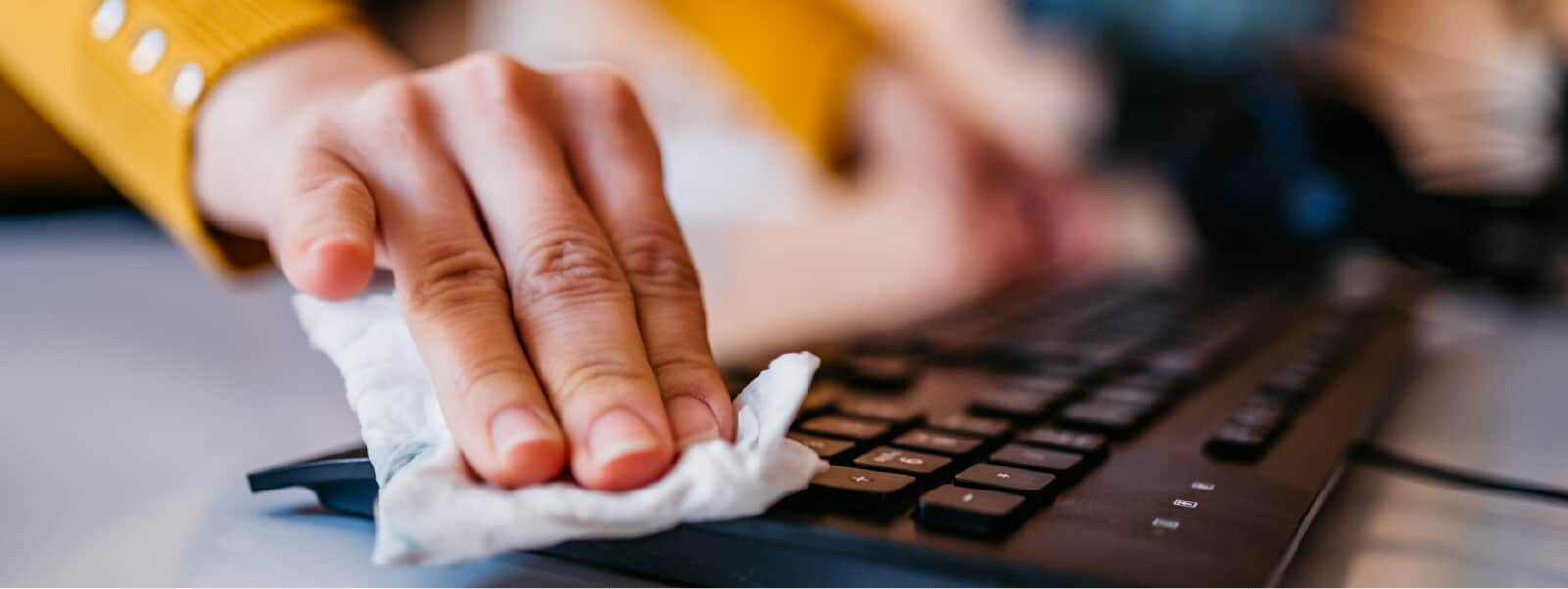 A person protecting their device by following essential computer maintenance tips.